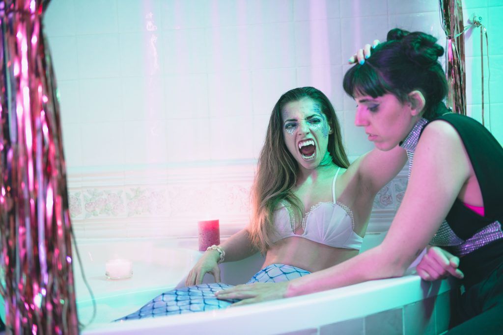 Andria García, vestida de sirena con colmillos, a punto de atacar a Margo Madison en la bañera en el videoclip de Like a mermaid